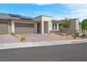 Inviting single-story home featuring desert landscaping, three-car garage, and mounted solar panels at 9608 Bloodstone Ln, Las Vegas, NV 89143