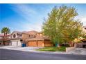 Suburban house with three car garage, desert landscaping, and mature trees in a well maintained community at 1017 Fairbury St, Henderson, NV 89052