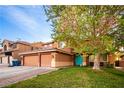 Charming two-story home with a well-maintained lawn, desert landscaping, and a welcoming, vibrant blue front door at 1017 Fairbury St, Henderson, NV 89052