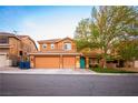Inviting home with a vibrant turquoise door, complemented by a lush green lawn and mature trees at 1017 Fairbury St, Henderson, NV 89052