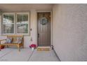 Inviting front door with a wreath, bench and a 'Happy Easter' door mat, plus potted flowers at 10385 Grassyrock Ct, Las Vegas, NV 89129