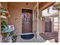Inviting front porch with decorated front door with a wreath and seating area at 1229 Swanbrooke Dr, Las Vegas, NV 89144