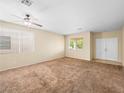 Spacious living room featuring neutral walls, plush carpeting, large windows, and a ceiling fan at 1307 Bayleaf Terrace Ave, Henderson, NV 89014