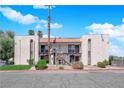 Exterior view of the charming two-story condo featuring a red tile roof, balconies, and mature trees at 1440 Vegas Valley Dr # 1, Las Vegas, NV 89169