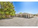 View of the home, detached garage, and large driveway with ample parking for multiple vehicles at 1911 Jarvis Rd, Pahrump, NV 89060