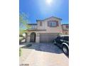 Inviting two-story home featuring desert landscaping, a brick driveway, and a two-car garage at 2409 W Gilmore Ave, North Las Vegas, NV 89032