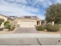 Single-story home featuring a brick driveway, desert landscaping, and solar panels at 2704 Willow Wren Dr, North Las Vegas, NV 89084