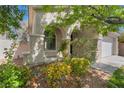Charming home featuring stucco exterior, arched entryway, and professionally landscaped front yard at 5100 Amethyst Creek Ct, Las Vegas, NV 89131