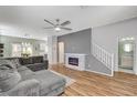 Cozy living room with a modern fireplace, ceiling fan, and hardwood floors at 5513 Nickel Ridge Way, Las Vegas, NV 89122