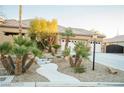 Beautiful home with a walkway, mature palm trees, and a three car garage at 5527 Breecher Ave, Las Vegas, NV 89131