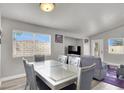 Bright dining area with a modern glass table, comfortable seating, and plenty of natural light at 5954 Rose Sage St, North Las Vegas, NV 89031