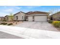 Attractive single-story home with a three-car garage and desert landscaping at 6261 Lamont Hills Ave, Las Vegas, NV 89139