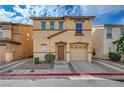Inviting two-story tan home with a one-car garage, arched entry and mature landscaping at 687 Porchtown Ave, Las Vegas, NV 89183