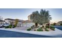 Inviting two-story house with a three-car garage, lush landscaping, and a well-kept lawn at 8136 Canyon Grassland St, Las Vegas, NV 89166