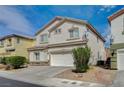 Side view of a two-story home with stucco facade and a two-car garage showcasing desert landscaping at 9732 Kampsville Ave, Las Vegas, NV 89148