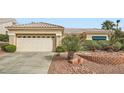 Inviting single-story home with a two-car garage, complemented by desert landscaping and a tiled roof at 10800 Brinkwood Ave, Las Vegas, NV 89134