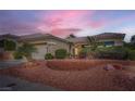 Inviting single-story home with a two-car garage, complemented by desert landscaping and a tiled roof at 10800 Brinkwood Ave, Las Vegas, NV 89134
