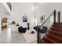 Bright living room features soaring ceilings, a modern staircase, neutral walls, and tile flooring that create an airy feel at 1136 Jamesbury Rd, Las Vegas, NV 89135