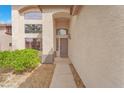 Home entrance with stucco walls, arched entryway, and desert landscaping at 1304 Autumn Wind Way, Henderson, NV 89052