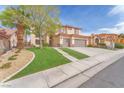Charming home with a well-maintained lawn, mature tree, three-car garage and stucco exterior at 1304 Autumn Wind Way, Henderson, NV 89052