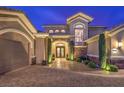 Elegant home entrance with stone accents, manicured shrubs, and a brick paver driveway at 1377 Ruby Sky Ct, Henderson, NV 89052
