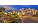 Elegant home boasts a manicured front yard, stone accents, and a brick driveway leading to a three-car garage at 1377 Ruby Sky Ct, Henderson, NV 89052