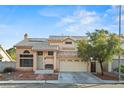 Charming two-story home with a tile roof, well-kept front yard, and attached two-car garage at 1705 Desert Ridge Ave, North Las Vegas, NV 89031