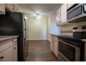 Kitchen showcasing stainless appliances, granite counters, and wood flooring leading to dining at 231 W Horizon Ridge Pkwy # 314, Henderson, NV 89012