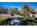 Outdoor tennis court with trees, landscaping, and a paved walkway leading to condos at 231 W Horizon Ridge Pkwy # 314, Henderson, NV 89012