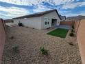 Low maintenance backyard with gravel landscaping, artificial turf, and a paved patio area at 247 Desoto Falls St, Indian Springs, NV 89018