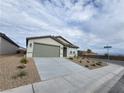 Charming single-story home featuring desert landscaping, a two-car garage and a welcoming entryway at 247 Desoto Falls St, Indian Springs, NV 89018