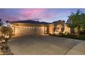 Home featuring a three-car garage, neutral stucco, stone accents, and landscaping at 379 Fynn Valley Dr, Las Vegas, NV 89148