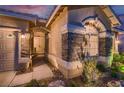 Inviting home entrance with stone accents, double doors and mature desert landscaping at 379 Fynn Valley Dr, Las Vegas, NV 89148
