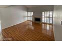 Bright living room features wood floors, a fireplace, shuttered windows, and natural light, creating an inviting space at 4037 Chalfont Ct, Las Vegas, NV 89121