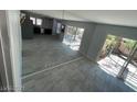 Open living area features tile flooring, sliding glass doors leading to a patio, and mirrored wall accents at 4037 Chalfont Ct, Las Vegas, NV 89121