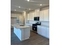 Modern kitchen with an island, stainless steel appliances, and white cabinetry at 4145 Texas Lilac Ave, Las Vegas, NV 89139