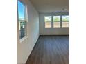 Bright living room featuring wood flooring and multiple windows offering natural light at 4145 Texas Lilac Ave, Las Vegas, NV 89139