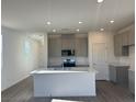 Modern kitchen features a center island, stainless steel appliances, and grey cabinets at 4153 Texas Lilac Ave, Las Vegas, NV 89139