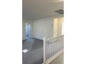 Open loft area with neutral carpet, ample natural light, and a white railing at 4153 Texas Lilac Ave, Las Vegas, NV 89139