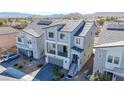 New home featuring solar panels, a balcony, a two-car garage, and a desert landscape in a Primary-planned community at 5745 Becklow Gardens Ave, Las Vegas, NV 89141