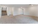 Spacious living area with neutral carpet, white walls, and access to stairs and other rooms at 5745 Becklow Gardens Ave, Las Vegas, NV 89141