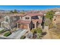 Beautiful two-story home showcasing a tile roof, stone accents, well-manicured landscaping, and mountain views at 605 Bachelor Button St, Las Vegas, NV 89138