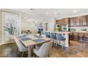 Open concept kitchen with granite counters, stainless steel appliances, island seating, and adjacent dining area at 605 Bachelor Button St, Las Vegas, NV 89138