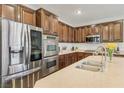 Close up of gourmet kitchen with stainless steel refrigerator and oven, and stone countertops at 605 Bachelor Button St, Las Vegas, NV 89138
