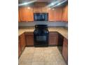 Well-lit kitchen with wooden cabinets, granite countertops, and a black oven and microwave at 6868 Sky Pointe Dr # 1034, Las Vegas, NV 89131