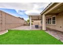 Lush backyard with artificial grass and a covered patio, ideal for entertaining guests at 7525 Campbell Ranch Ave, Las Vegas, NV 89179