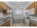 Well-maintained kitchen with tiled floors, wood cabinets, white appliances and natural light at 8805 Jeffreys St # 1018, Las Vegas, NV 89123
