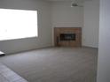 Spacious carpeted living room featuring a cozy fireplace and bright window at 10112 Plomosa Pl, Las Vegas, NV 89134