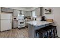Charming kitchen featuring gray cabinets, a breakfast bar, and stainless hood at 117 Saint Albans Ct, Henderson, NV 89015