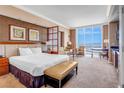 Comfortable bedroom suite featuring a king bed, sitting area, work space and large window at 135 E Harmon Ave # 3704, Las Vegas, NV 89109